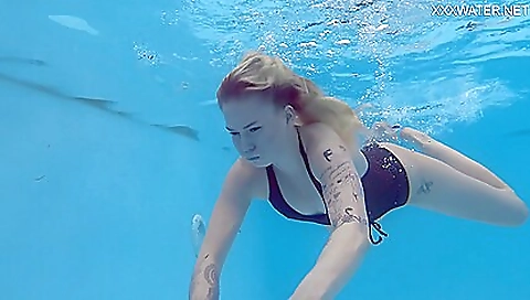 Sexy milf in a nude bikini is on the beach under water